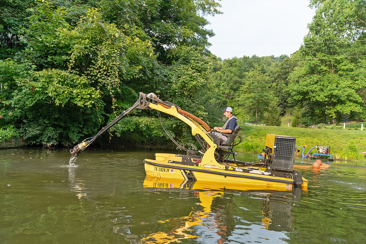 Man dredging in pond